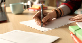 Cropped image of a women's hand writing on a piece of paper