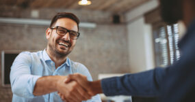 Two males shaking hands after a business agreement.