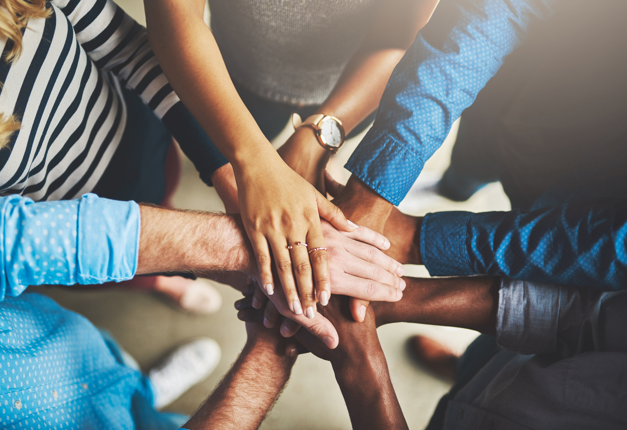 Diverse group of hands all putting them together