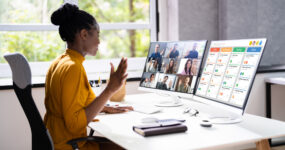 Female on work at home desk whilst being on a work call and analysing the project management tool